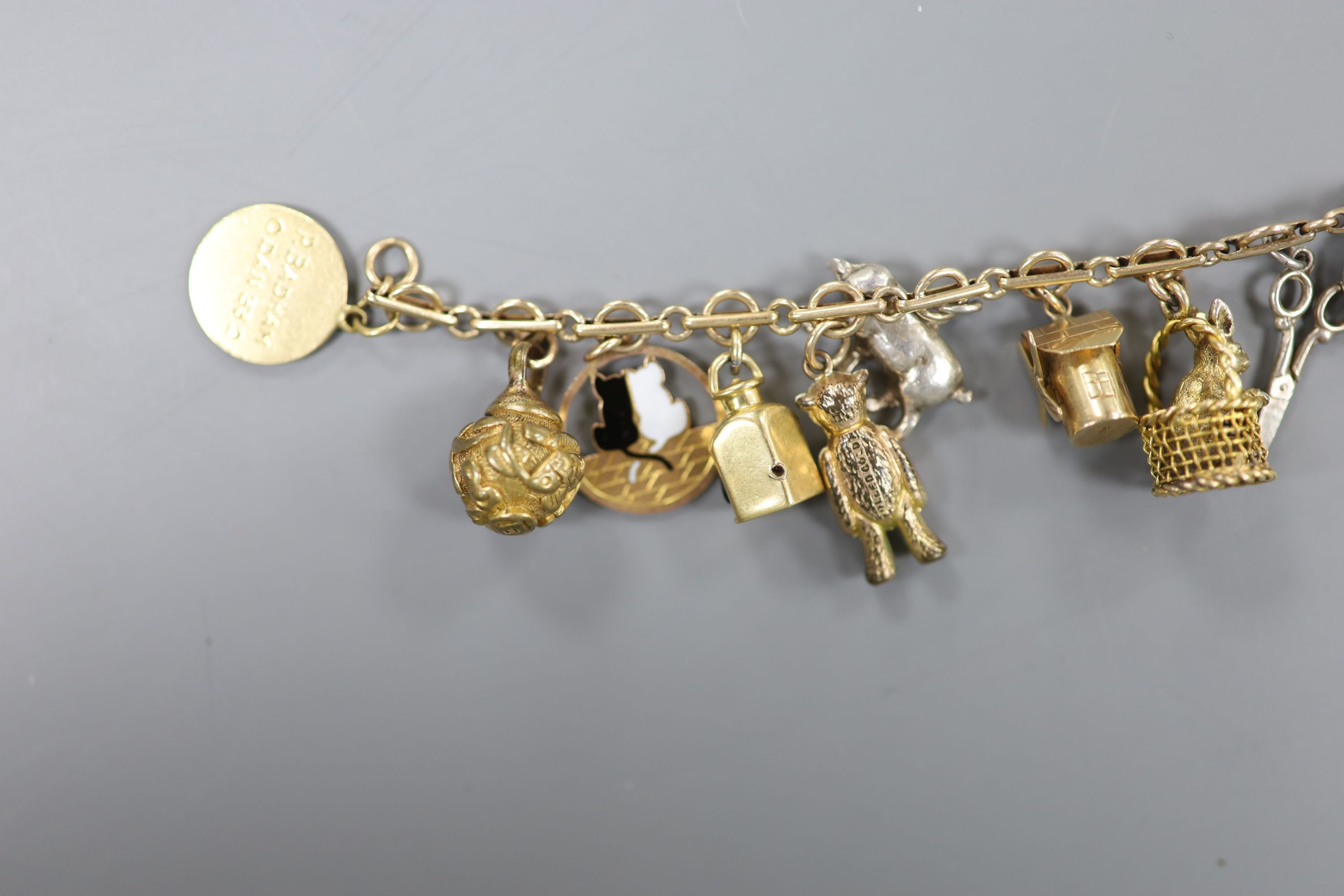 A 9ct charm bracelet, hung with assorted charms, gross weight 38.1 grams.